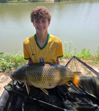 Ragazzo con una carpa regina pescata al Lago La Fenice