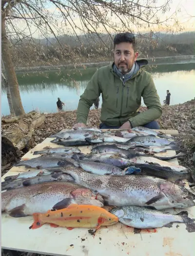 Pescatore con le trote della giornata, tra cui una trota dorata